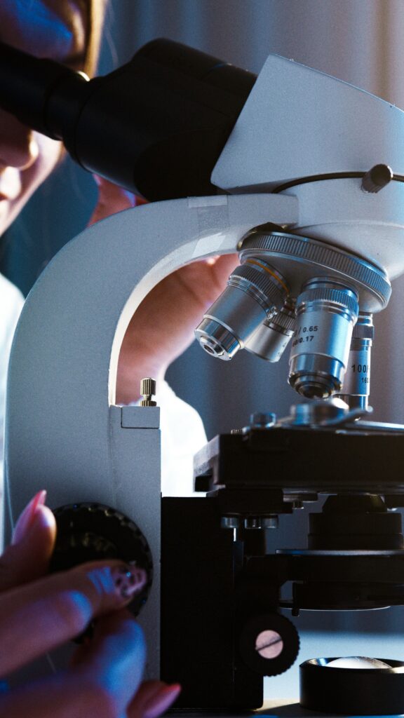 Close-up of a scientist conducting research with a microscope in a laboratory setting.